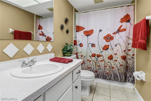 bathroom with toilet, oversized vanity, and tile flooring