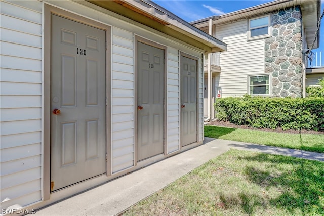 property entrance featuring a lawn