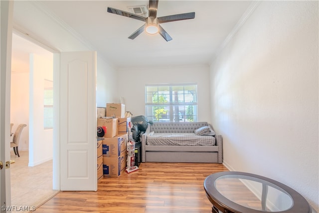 bedroom with light hardwood / wood-style flooring, ceiling fan, and ornamental molding