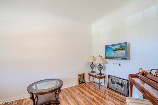 sitting room featuring wood-type flooring and crown molding