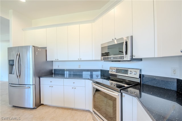 kitchen featuring appliances with stainless steel finishes, dark stone countertops, white cabinets, and light tile floors