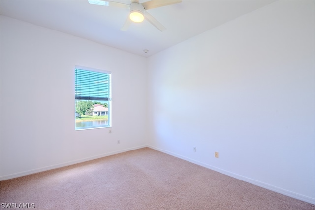 carpeted spare room featuring ceiling fan