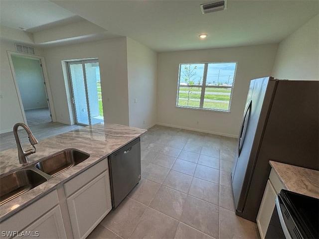 kitchen featuring white cabinets, stainless steel appliances, light tile patterned flooring, and sink