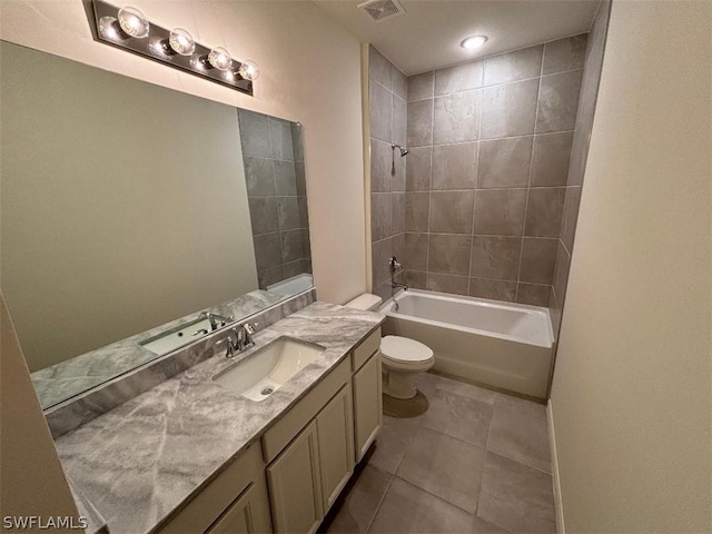 full bathroom featuring tile patterned flooring, tiled shower / bath combo, toilet, and vanity