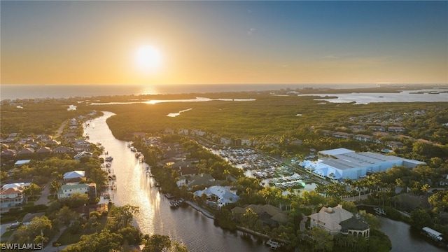 aerial view at dusk featuring a water view