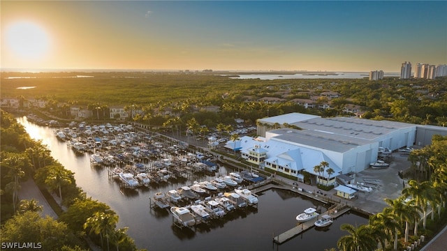 aerial view at dusk featuring a water view