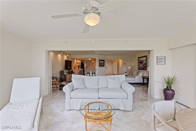 living room featuring ceiling fan and a textured ceiling