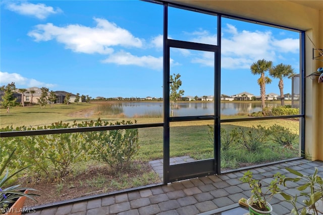 unfurnished sunroom featuring a water view