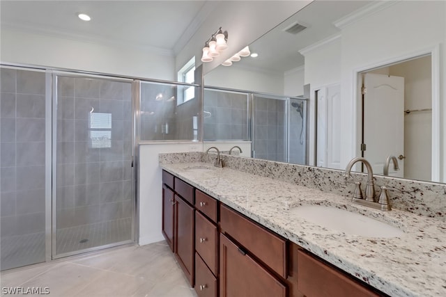 bathroom featuring tile patterned floors, ornamental molding, dual bowl vanity, and an enclosed shower