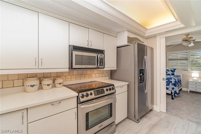 kitchen featuring white cabinets, ceiling fan, decorative backsplash, and appliances with stainless steel finishes