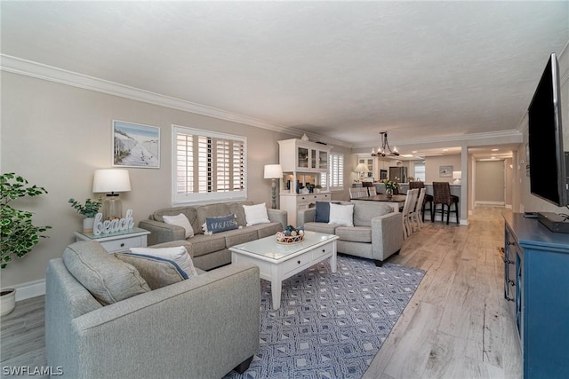 living room featuring a notable chandelier, light hardwood / wood-style floors, and ornamental molding