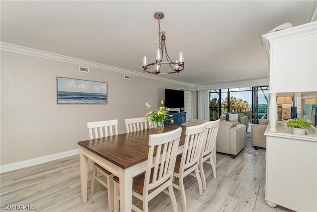 dining room featuring crown molding, light hardwood / wood-style flooring, and a notable chandelier