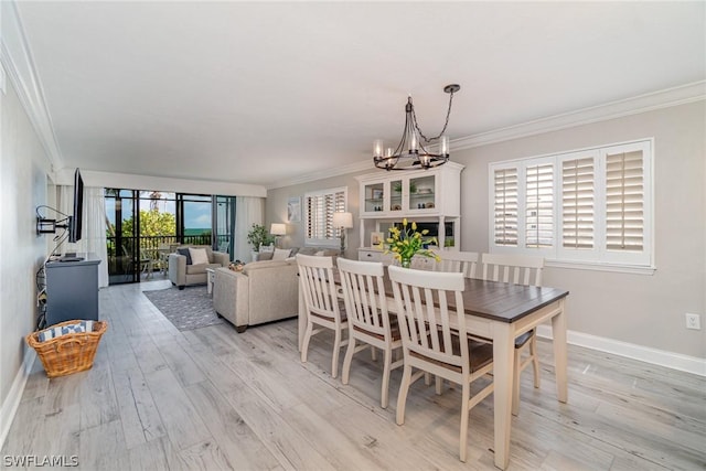 dining space with a healthy amount of sunlight, crown molding, light hardwood / wood-style flooring, and a chandelier