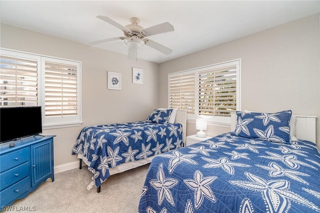 bedroom with multiple windows, light colored carpet, and ceiling fan