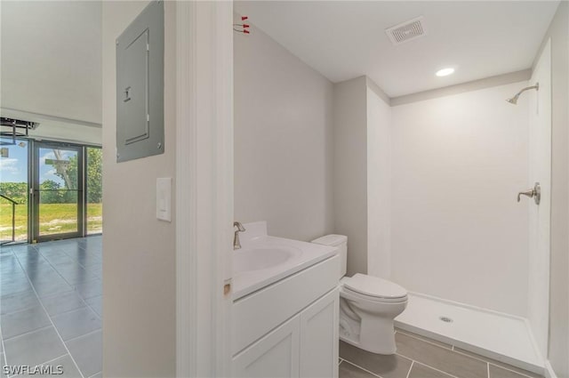 bathroom featuring vanity, electric panel, toilet, and walk in shower