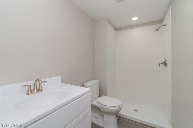 bathroom with vanity, toilet, and a shower