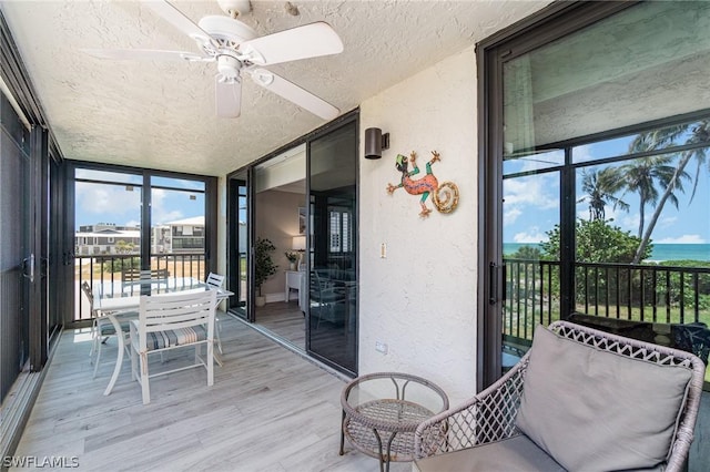 sunroom / solarium featuring ceiling fan