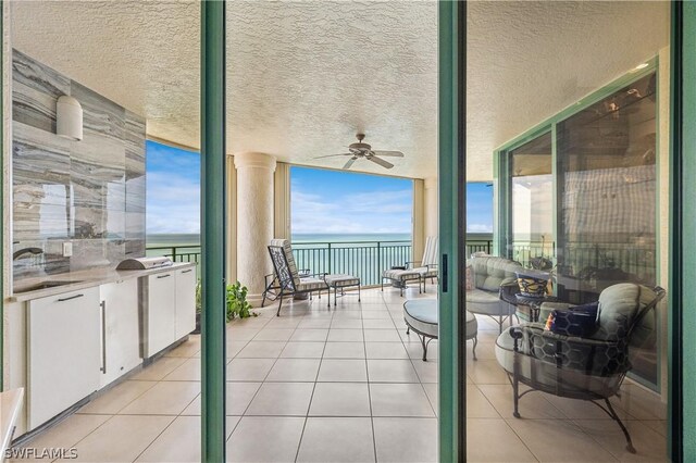 view of terrace with a water view and ceiling fan