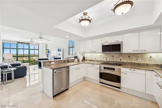 kitchen with kitchen peninsula, appliances with stainless steel finishes, and a healthy amount of sunlight