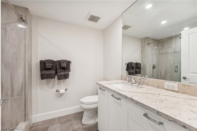 bathroom with tile floors, vanity with extensive cabinet space, toilet, and walk in shower