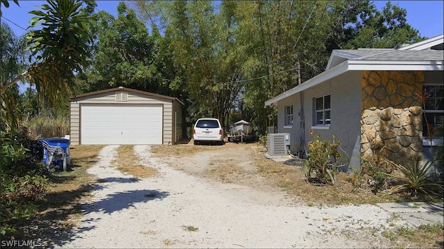 view of side of property with central air condition unit, an outdoor structure, and a garage