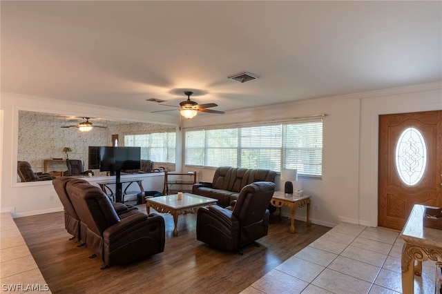 living room featuring ceiling fan, ornamental molding, and light hardwood / wood-style flooring