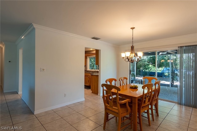 tiled dining room with crown molding and an inviting chandelier