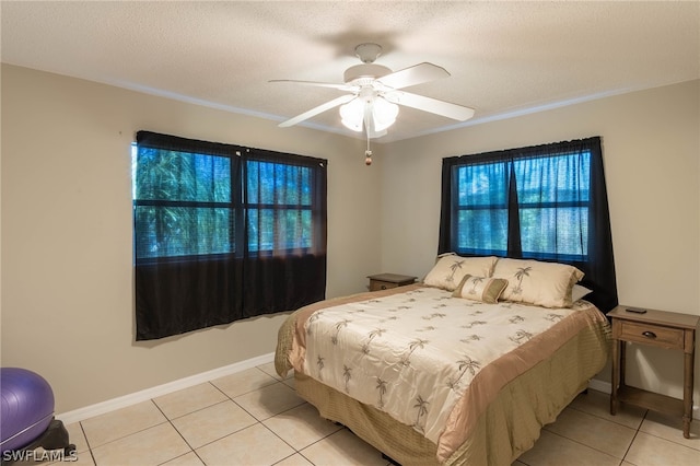 tiled bedroom with ceiling fan and a textured ceiling