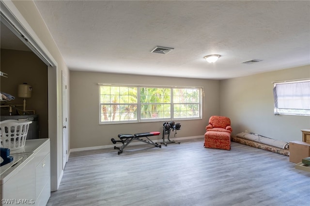 sitting room featuring light hardwood / wood-style floors, a textured ceiling, and washer and clothes dryer