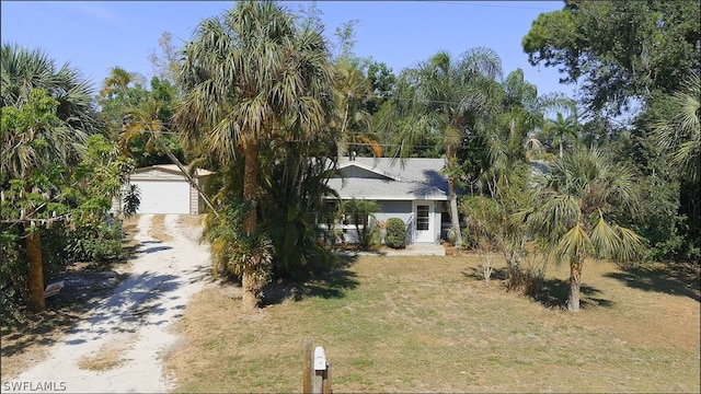 view of front of home featuring a front yard, an outdoor structure, and a garage