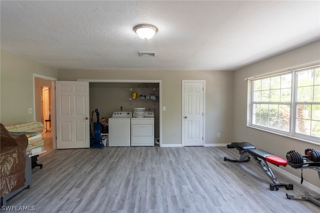 interior space with washer and dryer, a textured ceiling, and light wood-type flooring