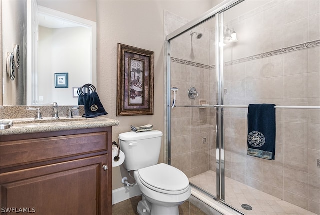 bathroom with a shower with shower door, toilet, and vanity