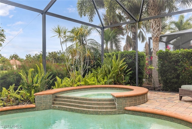 view of pool with an in ground hot tub, a lanai, and a patio