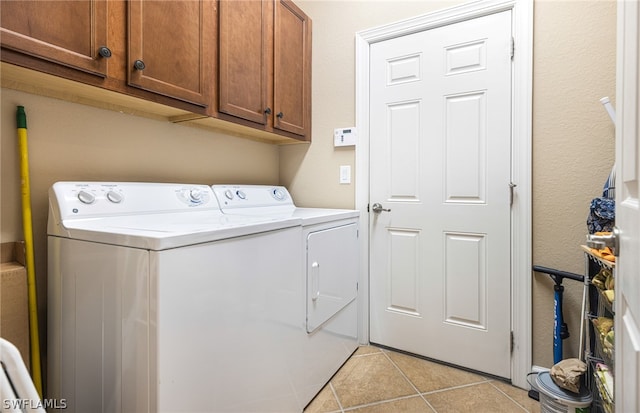 washroom featuring cabinets, light tile patterned floors, and independent washer and dryer