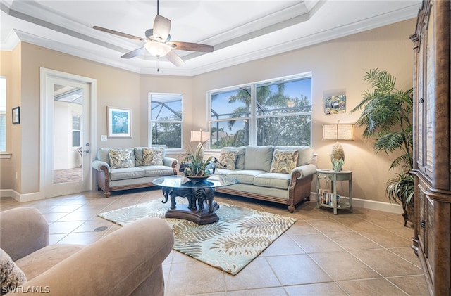 tiled living room featuring ceiling fan, a raised ceiling, and crown molding