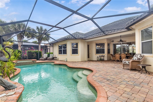 view of pool with an in ground hot tub, glass enclosure, ceiling fan, and a patio area