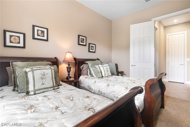 bedroom with lofted ceiling and tile patterned flooring