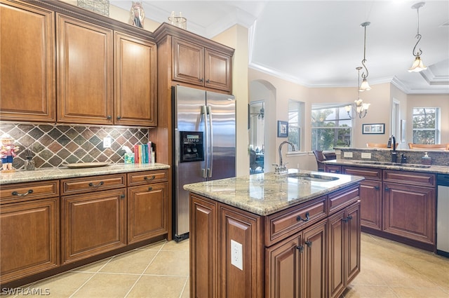 kitchen featuring stainless steel appliances, decorative light fixtures, crown molding, and sink