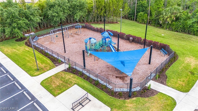 view of home's community featuring a playground and a yard