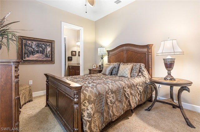 bedroom with ceiling fan, connected bathroom, and light carpet