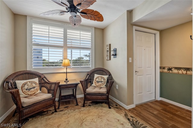 living area with wood-type flooring and ceiling fan