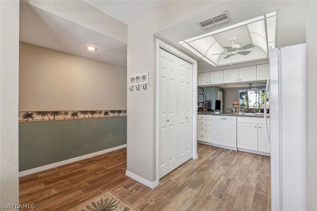 kitchen with ceiling fan, white cabinets, sink, white appliances, and wood-type flooring