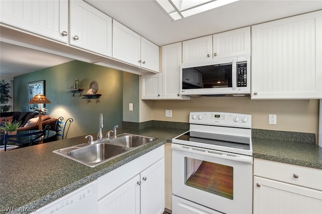 kitchen featuring white appliances, sink, and white cabinetry