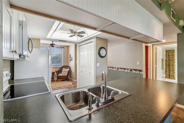 kitchen featuring sink, ceiling fan, range, white cabinets, and hardwood / wood-style floors