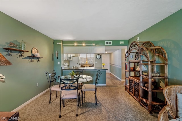 dining area with sink and light hardwood / wood-style floors