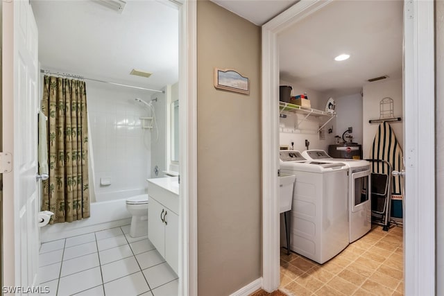 laundry area featuring washing machine and dryer, electric dryer hookup, water heater, hookup for a washing machine, and light tile floors