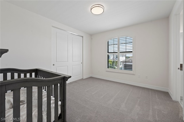 bedroom featuring light carpet, a closet, and a nursery area