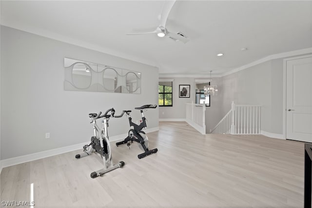 exercise area featuring a chandelier, light hardwood / wood-style flooring, and crown molding