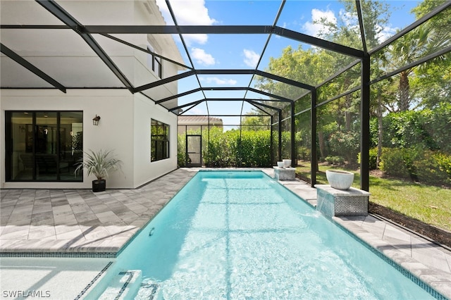 view of swimming pool with pool water feature, a patio, and glass enclosure