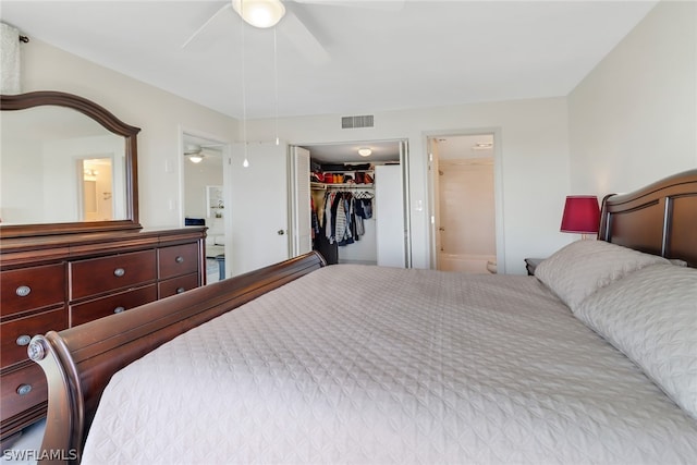 bedroom featuring a spacious closet, connected bathroom, a closet, and ceiling fan